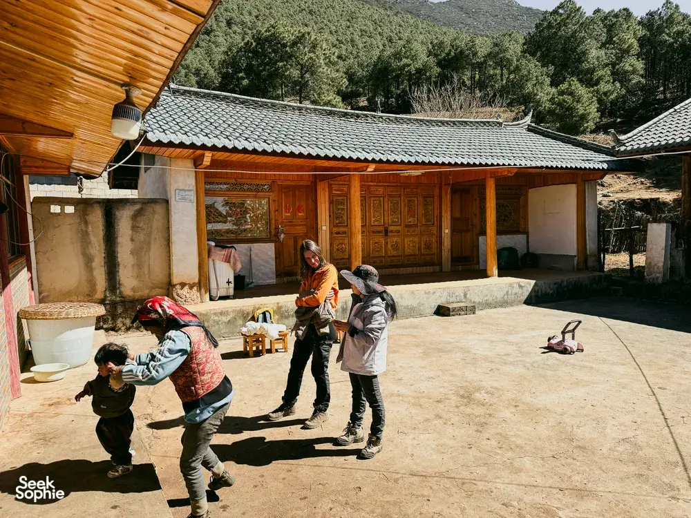 Walkway in a courtyard as trekkers head from a village house towards the mountains near Lijiang on the Yi & Naxi trek