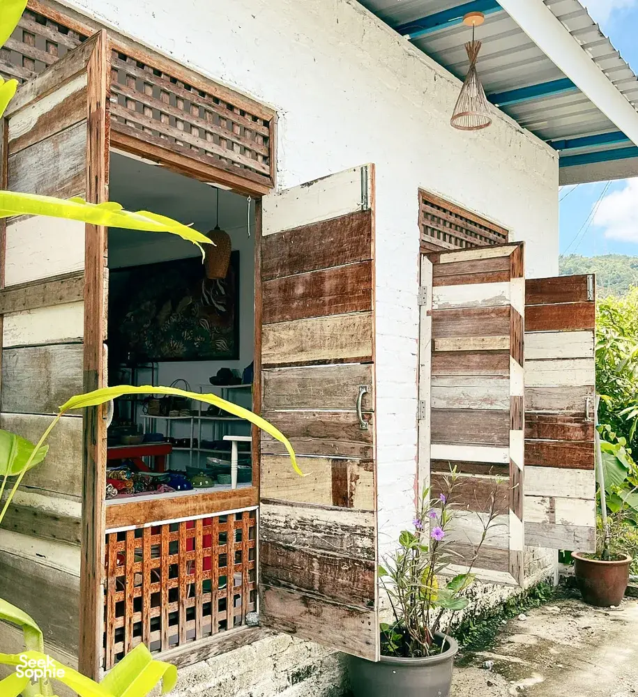 Ilham Ceramic studio exterior in Langkawi village with open wooden shutters, shaded shelves and potted flowers