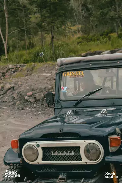 Ayla Tour jeep on a rocky track heading on Mount Merapi adventure, with green 4x4 front view in Yogyakarta