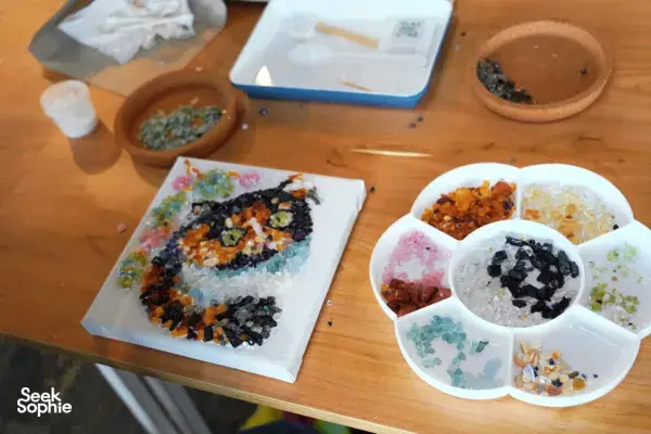 Trays and bowls of coloured gemstones on a wooden table for hands-on mindful team workshops in Singapore