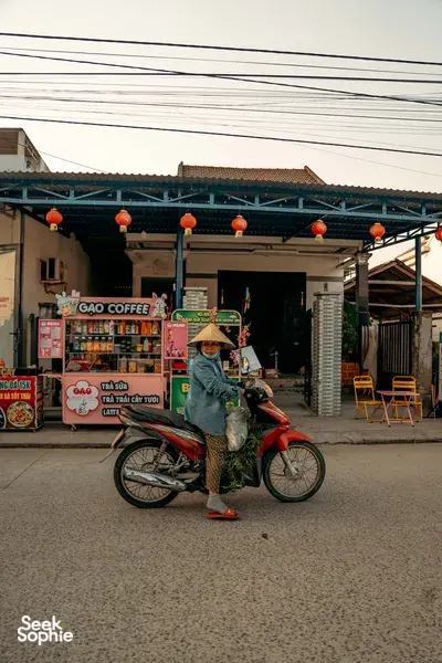 Motorbike rider waiting outside a Vietnamese coffee shop in Hoi An, captured during a street stop on a guided tour