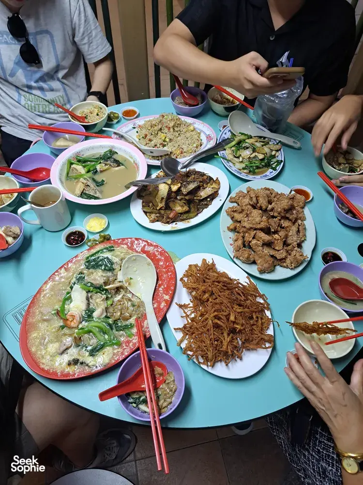 Meja kongsi dengan hidangan penjaja Kantonis di Singapura, para pengunjung menggunakan penyepit dan mangkuk sambil makanan dihidangkan untuk dikongsi bersama