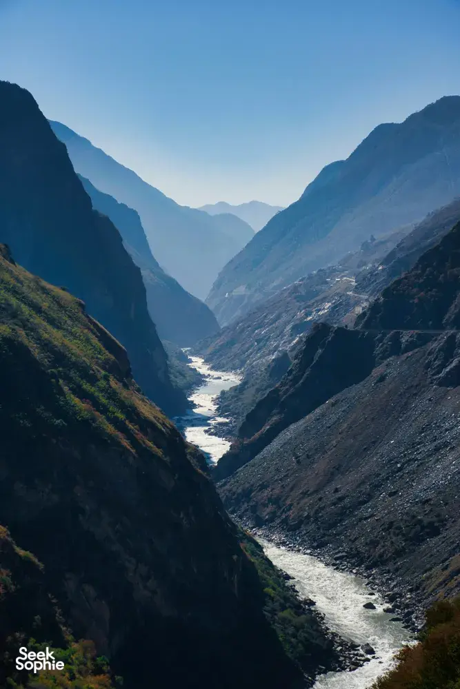 Winding river through deep mountain valleys in Shangri-La, viewed from a hiking trail overlook at blue hour