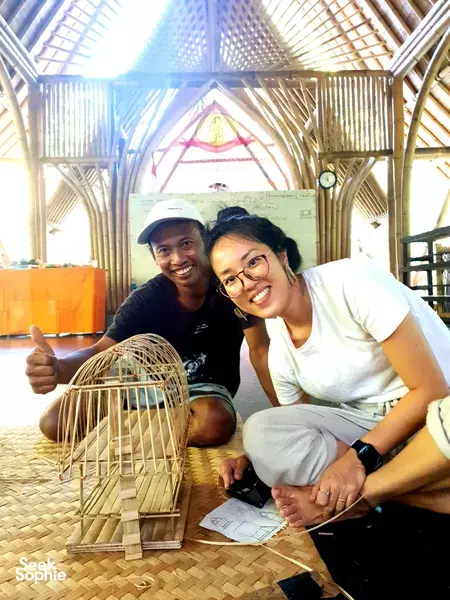 Bamboo Creative Bali in Bali: two smiling makers pose in a bamboo workshop with a finished woven bamboo dome structure