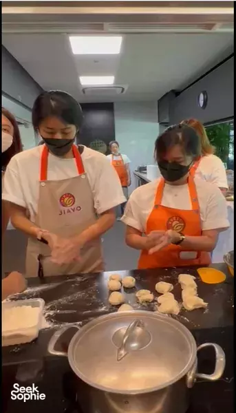 Hands shaping dough balls on a tray at a Taiwanese night market cook-off together for workshops in Singapore