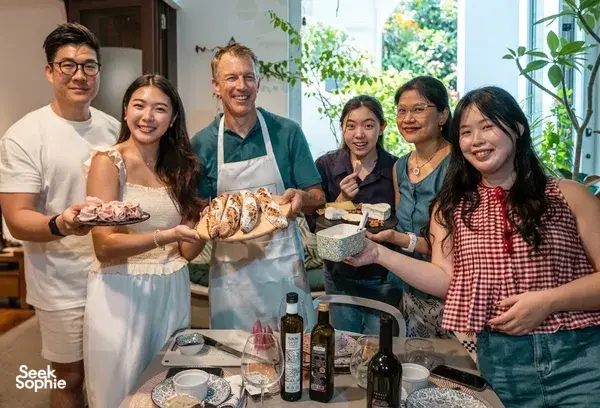 Travellers with a French chef shaping baguettes in a Singapore kitchen for a private group baking class — workshops in Singapore