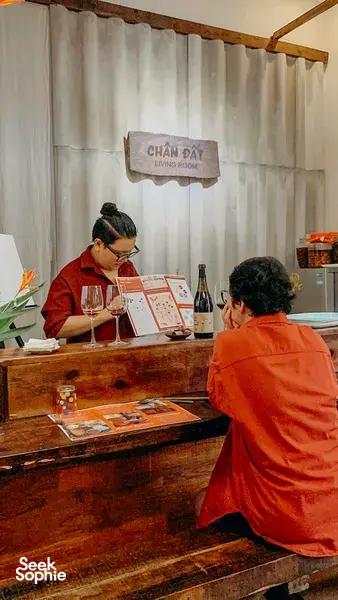 Host and guests sit at a wooden counter at Chan Dat Living Room in Hoi An, sharing a guided Deep Cultural Tasting