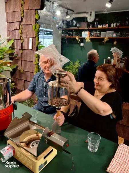Private chocolate-making workshop in Singapore: adults lift beans from a roaster while preparing chocolate, workshops in Singapore