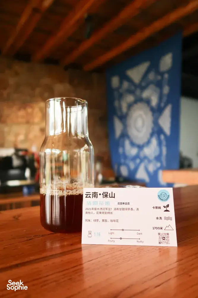 Glass coffee carafe and tasting card on a wooden table in a Lijiang coffee workshop at Seeker Yunnan Coffee Estate