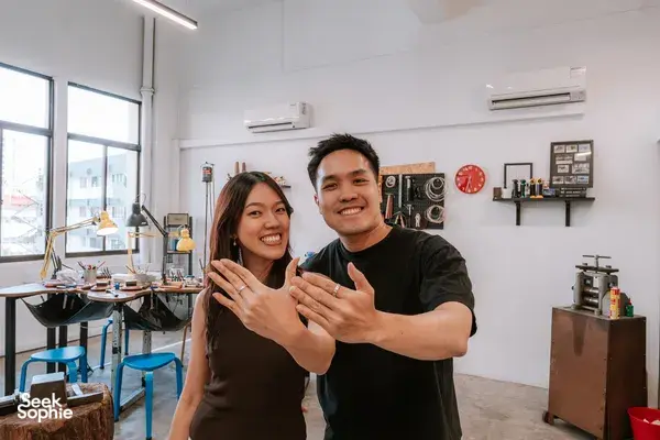 Couple smiling and showing handmade rings at Fat Anvil Studios silversmithing studio in Singapore for date ideas Singapore