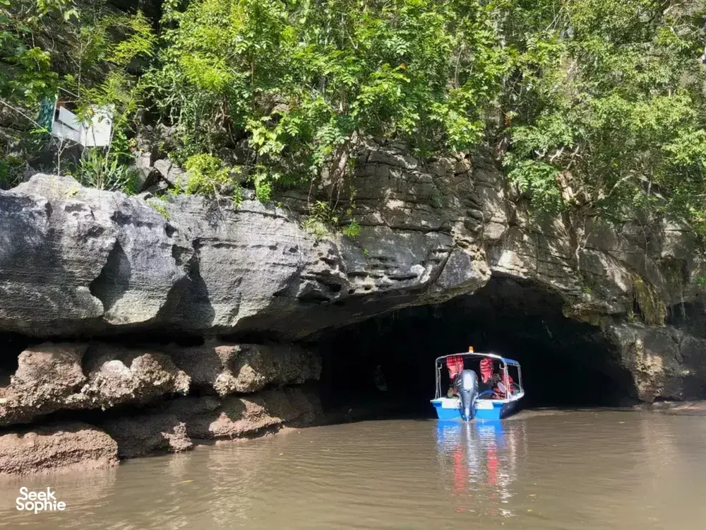 Boat drifting into a limestone cave along Langkawi’s UNESCO Geopark waterways during the cruise