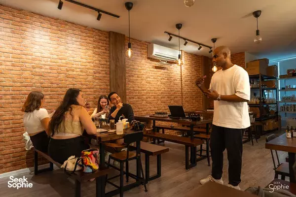Essential oil blending workshop in a brick-walled Singapore studio, with an instructor guiding a seated group, workshops in Singapore