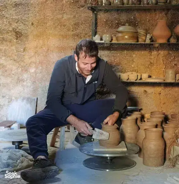 Jay from Discovery More shapes clay on a pottery wheel during an ancient pottery village visit in Shangri-La, Yunnan