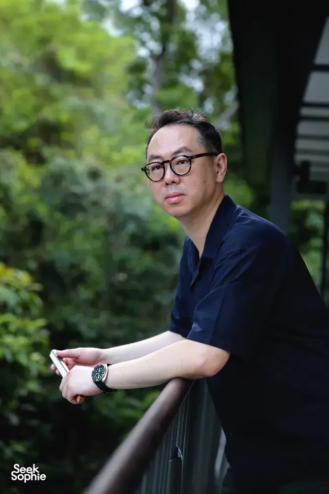 Chong Zheng Calligraphy instructor holding a calligraphy brush outdoors during a write-your-own blessing session—workshops in Singapore