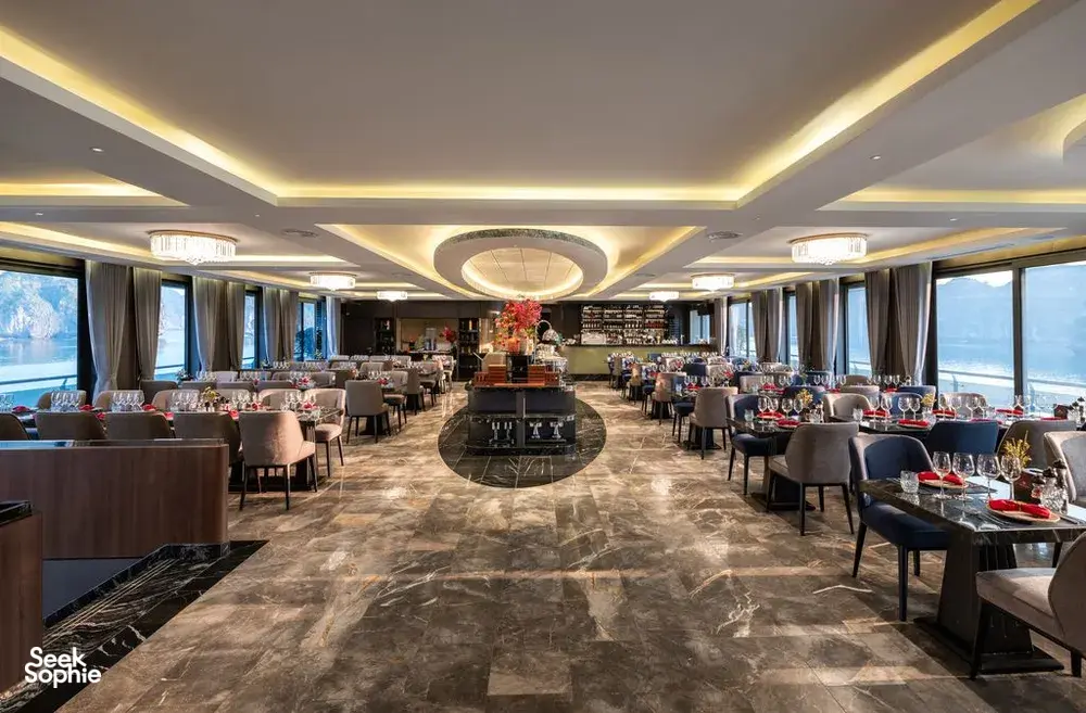 Doris Cruise 5-star dining room with set tables and panoramic windows overlooking views from the ship in Halong Bay