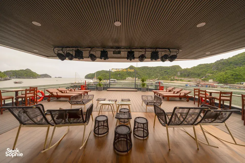 Sunshine Golden Cruises sundeck lounge with cushioned chairs and shelter, overlooking the bay and green hills in Cat Ba