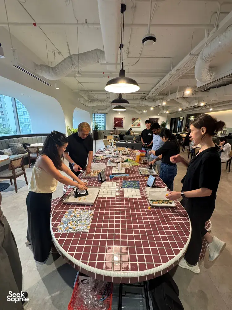 Team workshop in Singapore with Agrihome: participants cutting reusable food-wrap sheets at a long table for team building Singapore