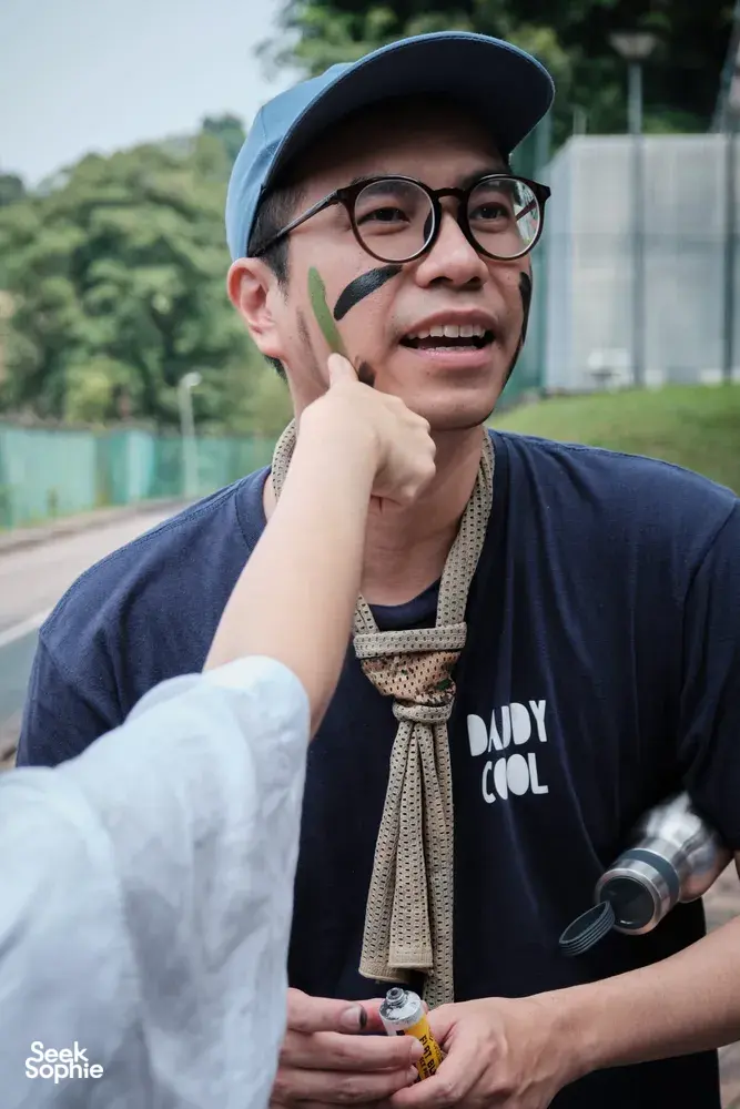 Beyond Expeditions founder Scott Tay in Singapore with green face paint and glasses, pointing during the Fort Serapong challenge
