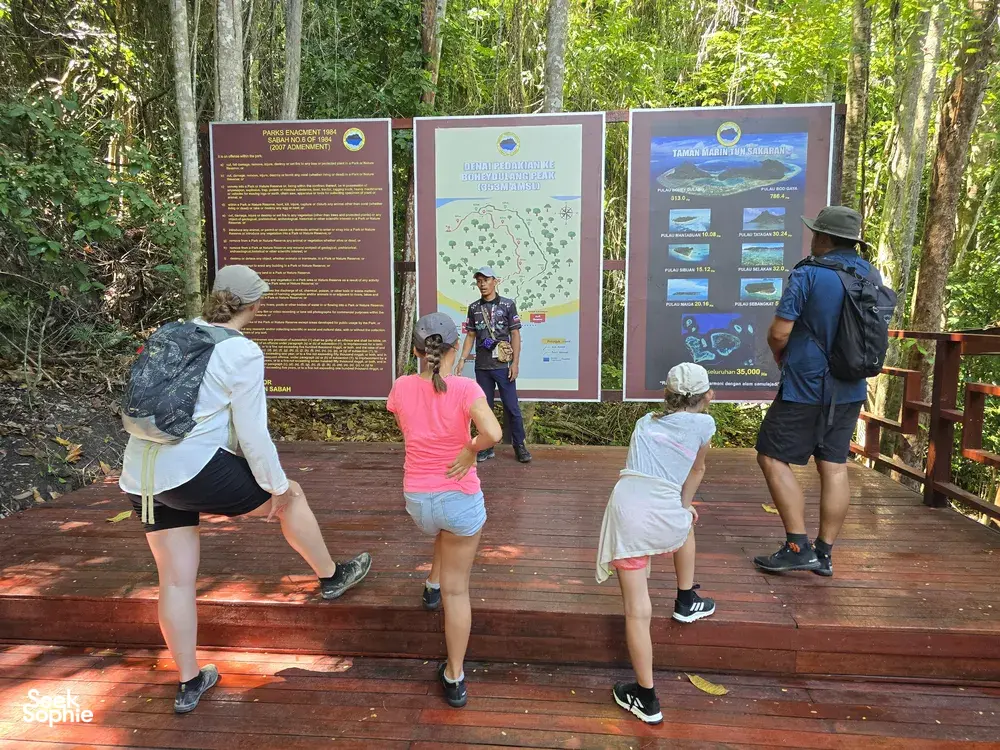 Taklimat pendakian Bigfin Divers di Semporna: para pengembara berjalan di laluan kayu di sisi peta marin di dalam hutan