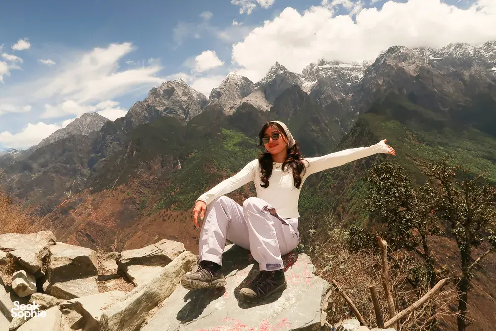 Hiker posing on a rocky lookout above Tiger Leaping Gorge, Lijiang, on a 2D1N host-led high-trail trek
