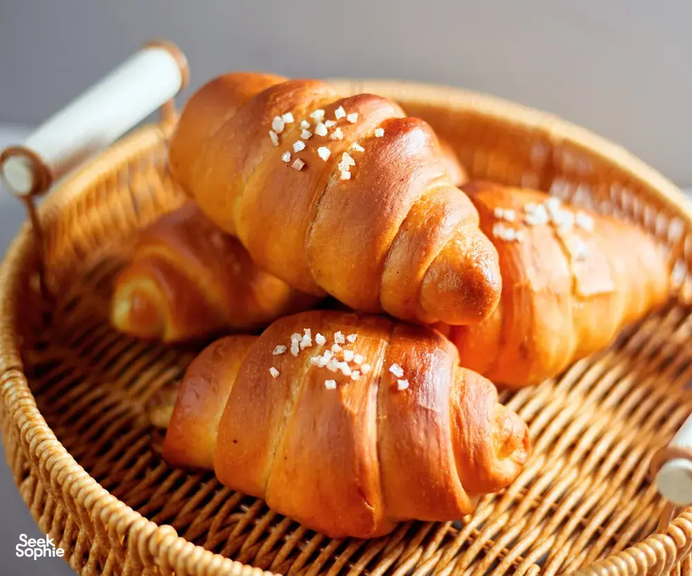 Shio pan rolls with pearl sugar resting in a wicker basket on a table during a Singapore baking workshop