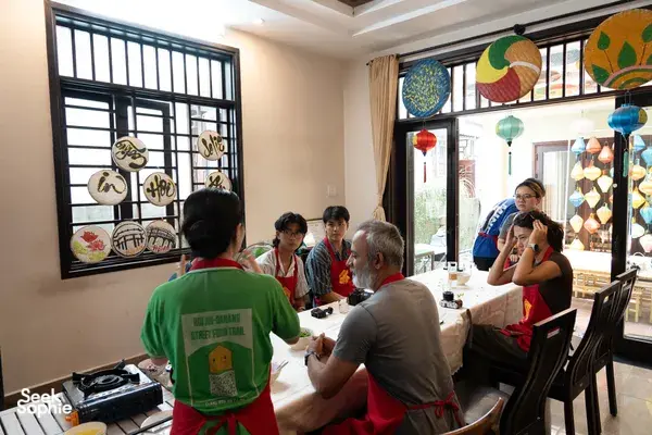 会安 Jolie 烹饪课：客人围坐在共用餐桌旁，在 Jolie 家中一边聊天，一边准备共享的家常餐食