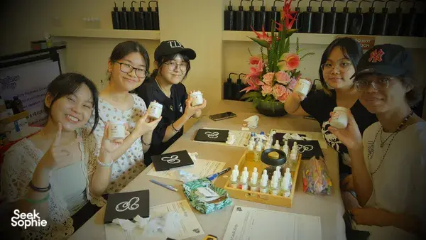 Smiling group at Perfume Play’s workshops in Singapore, making scented coco-soy candles with fragrance tools on a shared table