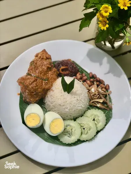 Nasi lemak-style plate with fried chicken, boiled eggs and cucumber on banana leaf at Kebun Lidstari farmhouse kitchen in Langkawi