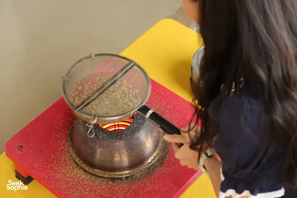 Guest tasting roasted coffee beside a metal filter during a Seeker Yunnan Coffee Estate session in Lijiang
