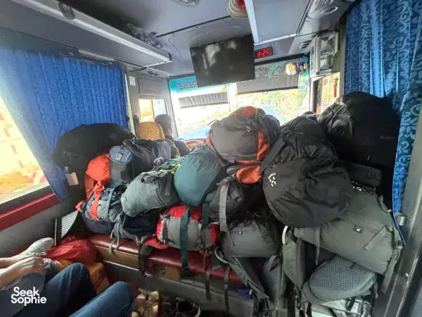 Luggage piled up on seats inside a Son Tung Express bus for the Cat Ba to Halong transfer, ferry tickets included