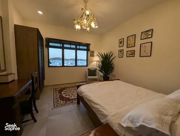 Cozy bedroom with chandelier light and a sea-view window at The Unexpected’s Singapore farmstay by the sea for 2D1N