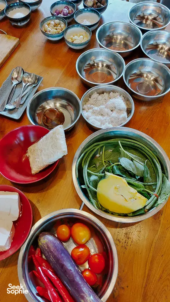 Ingredients for a Manggarai vegan cooking class—bowls of vegetables, herbs and grains—on a table in Labuan Bajo