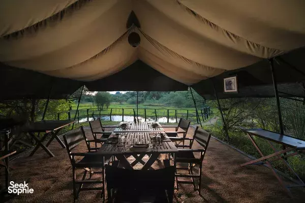 Leopard Trails safari dining set under a canvas tent in Wilpattu, with a long table and chairs by the greenery