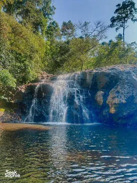 Waterfall cascading into a pool amid lush forest in Khao Yai National Park for wildlife trekking days