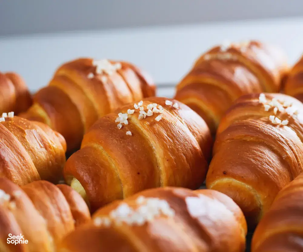 Golden shio pan rolls sprinkled with pearl sugar on a baking tray, prepared for hands-on workshops in Singapore