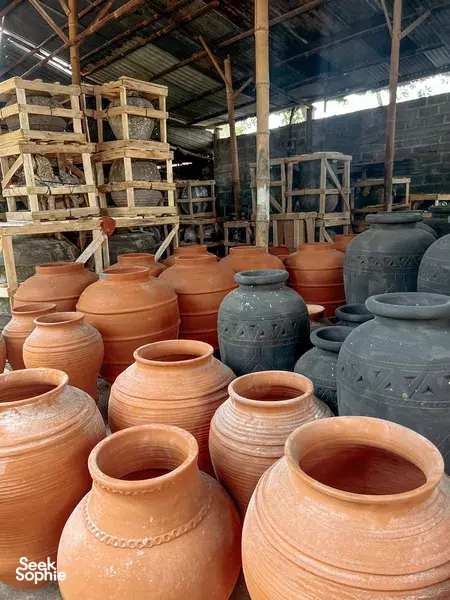 Rows of terracotta jars and large clay pots stacked in a pottery workshop, showcasing artisan kiln wares, Yogyakarta
