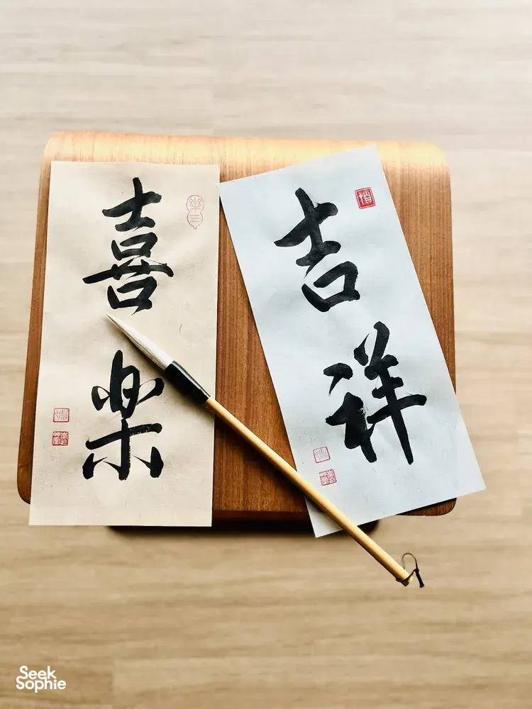 Chinese calligraphy sheets on a wooden writing board with a brush, ready to write a blessing—workshops in Singapore