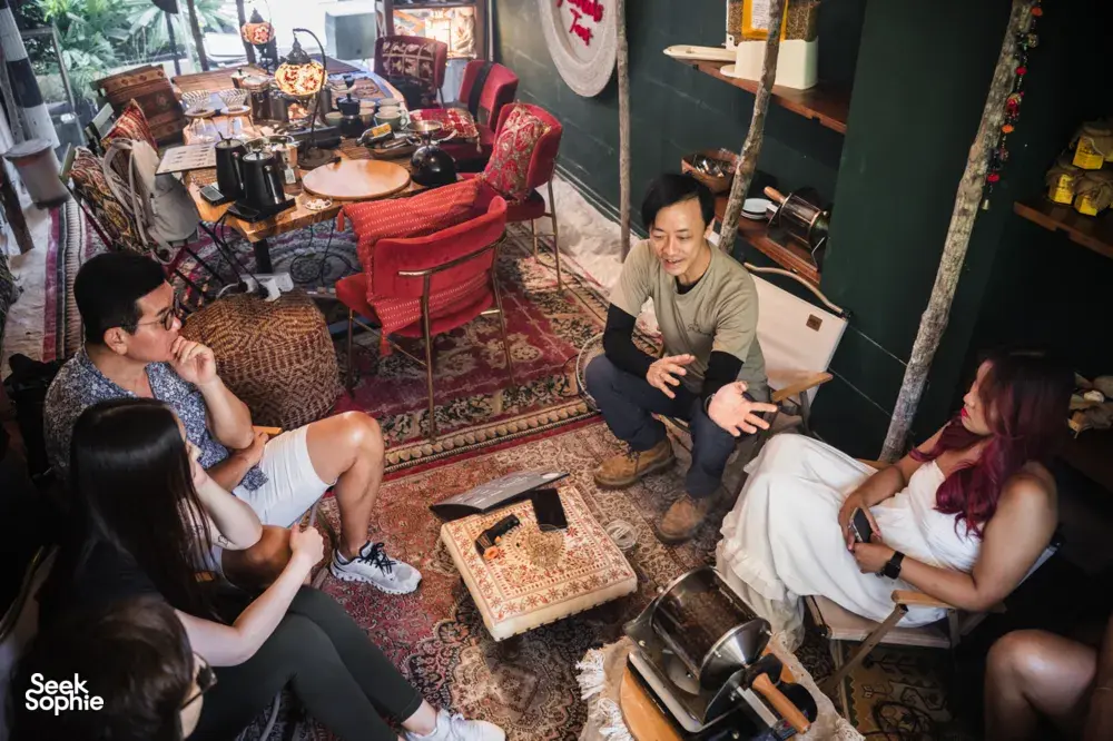 Guests gather by coffee-making equipment while an instructor explains tasting for bagel brunch in Singapore, workshops in Singapore