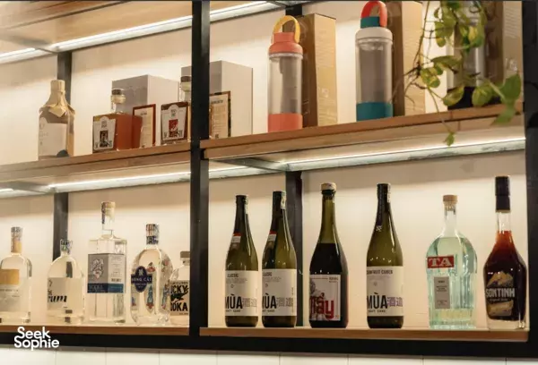 Shelves of craft spirits bottles and glassware in a Ho Chi Minh City tasting bar for cocktails and craft spirits