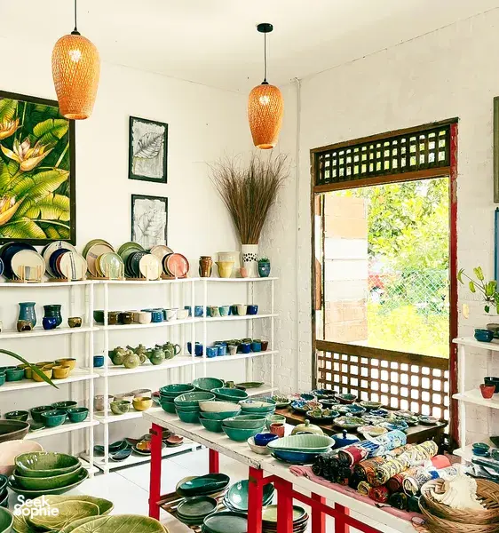 Ilham Ceramic Studio in Langkawi village with shelves of handmade bowls, cups and plates under hanging lamps