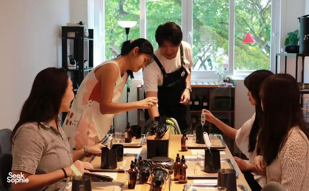 Guests pouring wax during WICKKA STUDIO crystal candle making & manifestation candle workshop in Singapore, guided by the host
