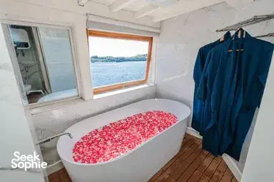 Cabin interior on a Komodo boat trip with bed and window seating on the deck, hosted by La Famille in Labuan Bajo