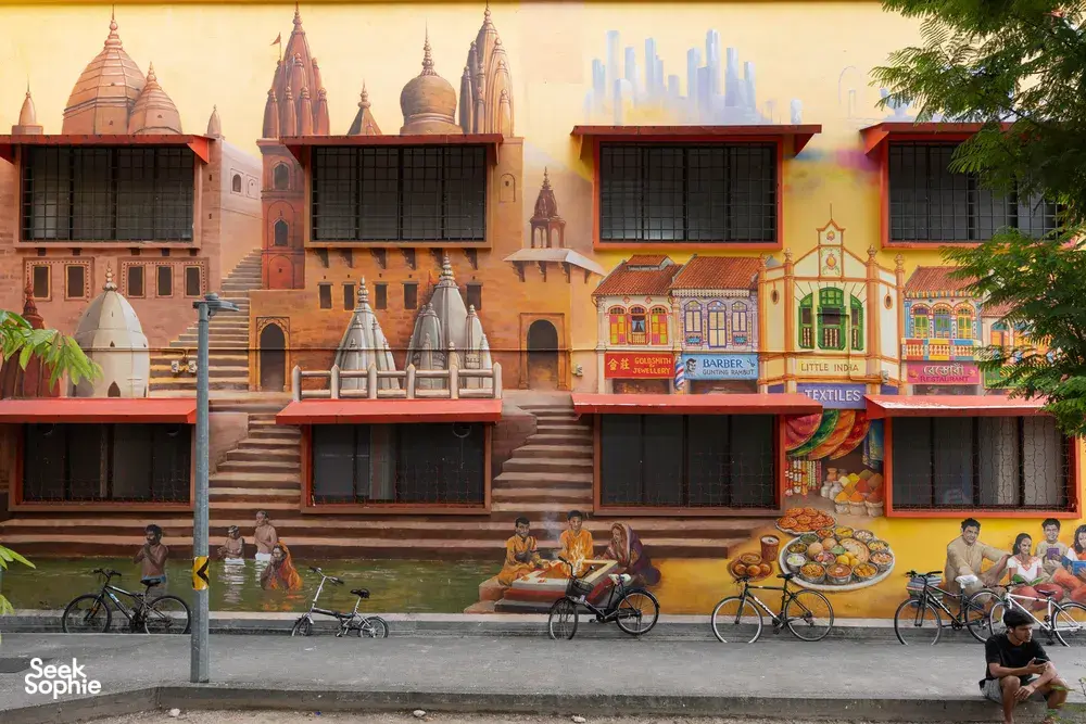 Vibrant mural wall with shopfront scenes behind parked bicycles on a Singapore street in Jalan Besar, Singapore hidden gems