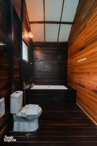 Wood-panelled bathroom with toilet and tiled floor at Borneo Natural Sukau Bilit Resort, safari stay on the Kinabatangan River