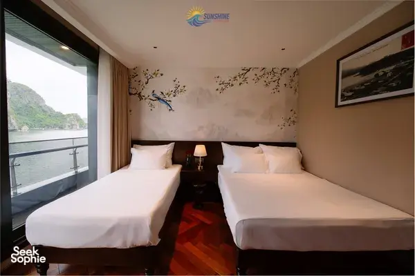 Sunshine Golden Cruises twin cabin on a Cat Ba cruise with two beds and floor-to-ceiling window overlooking the bay