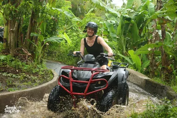 Helmeted rider splashing on a muddy quad through lush banana groves on a track with Gordo Bali Tour near Ubud