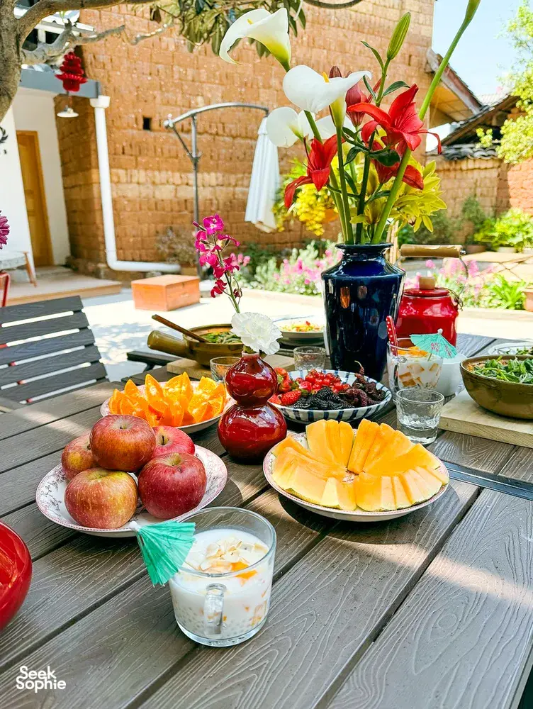 Fresh Yunnan produce and dishes laid out on a table in a Lijiang courtyard for a market-to-table cooking session