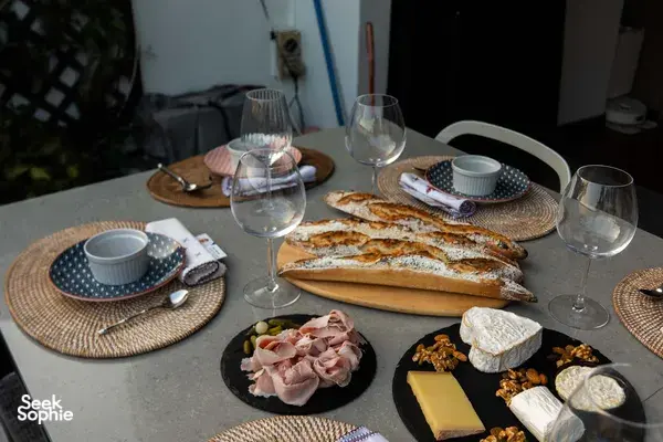 Loft dining table set with French baguettes, cheese and cured meats beside wine glasses in Singapore for private dining Singapore