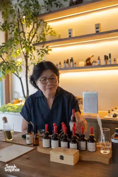 Hyuuga’s Zack Lee personalising a natural pillow mist at an essential-oil workshop in Singapore, with droppers and bottles on the table