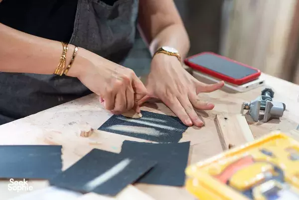 Hands shaping wooden pieces at a workbench with clamps and tools during a Singapore woodworking jewellery workshop — workshops in Singapore